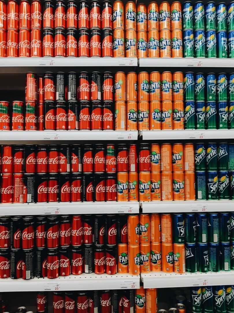 Rayon de supermarché remplis de soda en canette.