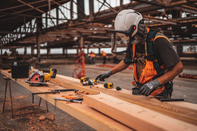 Ouvrier en tenue de sécurité travaillant le bois