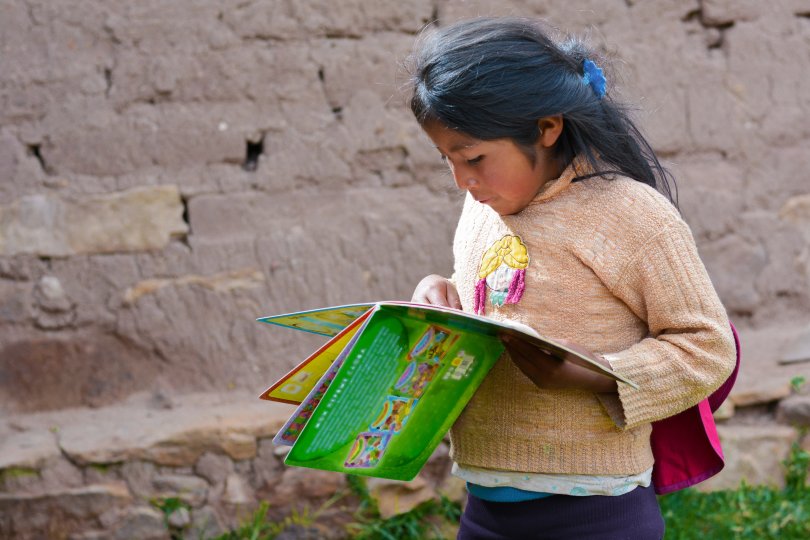 Petite fille amérindienne lisant un livre à la campagne.