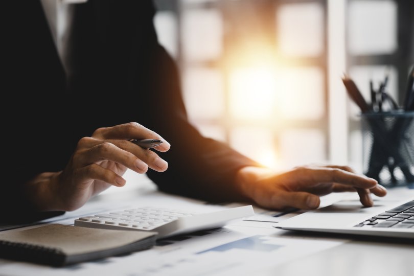 Mains de femme en costume d'entreprise sur un bureau et utilisant une calculatrice 