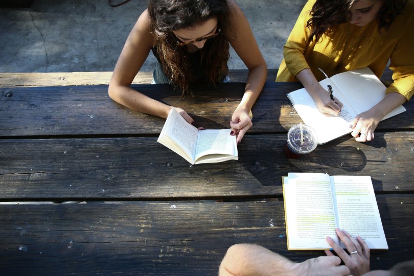 femme lisant un livre assis sur une chaise.