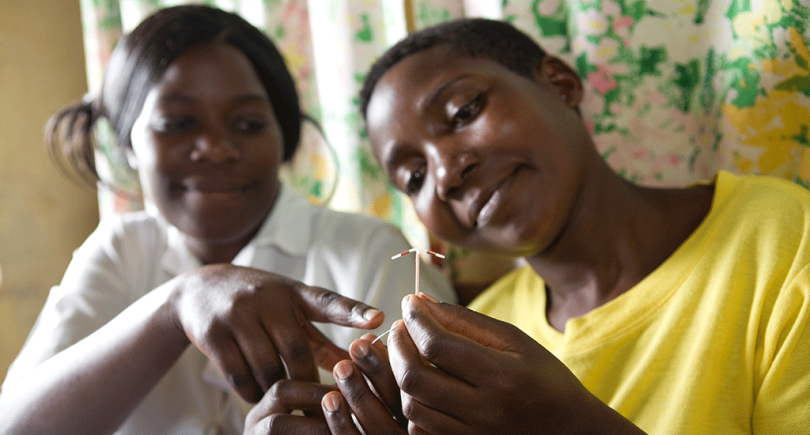 Une cliente du centre de santé musulman de Kawoko, en Ouganda, tient un stérilet pendant qu'une sage-femme la conseille.