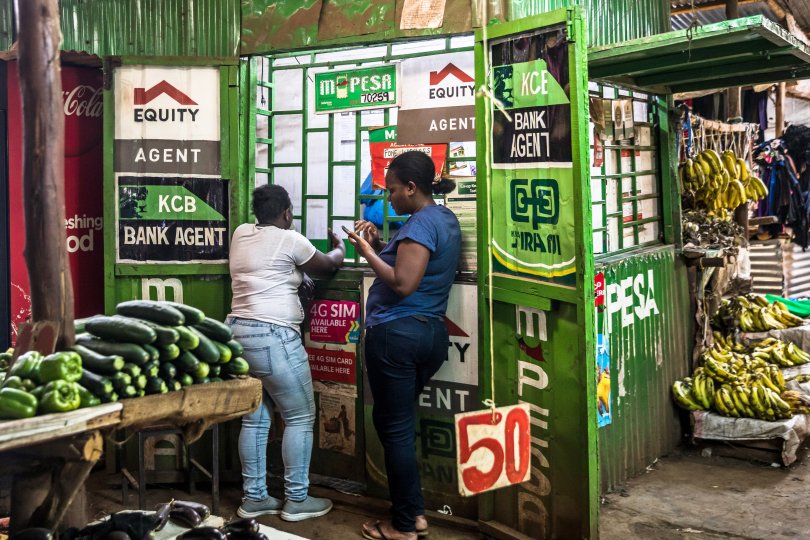 Des clients utilisent les services M-pesa dans un kiosque du Toi Market, un marché en plein air et l'endroit préféré pour acheter des articles d'occasion, des vêtements, des chaussures ou simplement des fruits et légumes frais à Nairobi.