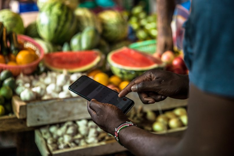 Un client utilise son téléphone pour effectuer un paiement au Toi Market, un marché en plein air et l'endroit préféré pour acheter des articles d'occasion, des vêtements, des chaussures ou simplement des fruits et légumes frais à Nairobi, au Kenya.